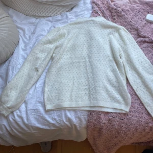Vit stickad tröja från Stories XS - Superfin vit stickad tröja från Stories i storlek XS. Tröjan har ett diskret hålmönster över hela och mjuka, långa ärmar. Perfekt för lager-på-lager och ger en clean, fräsch look till din outfit.