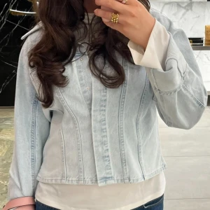 Ljusblå jeansjacka med markerad söm - Säljer en ljusblå jeansjacka med markerade sömmar och klassisk krage. Jackan har en rak passform och knäppning framtill. Perfekt för dig som gillar en clean och stilren look. Den är helt ny med lappar kvar därav priset❣️