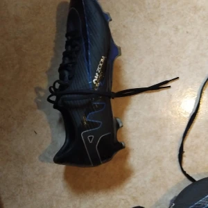 Nike Air Zoom Svarta Fotbollsskor - Snygga svarta Nike Air Zoom fotbollsskor med vita detaljer och snörning. Skorna har en sportig design med låg profil och är tillverkade i syntetmaterial för bästa prestanda på planen. Perfekta för dig som vill ha stil och funktion i ett. Nuvarande pris 1100kr men kan diskutera 