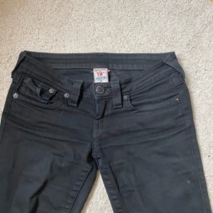Svarta true religion - Snygga svarta vintage true religion jeans. Dom är väldigt lågmidjade och bootcut. Midja: 37 cm raköver innerben: 79 cm Pris går diskutera!