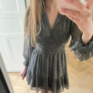 Svartvit prickig  klänning🫰🏻 - Somrig  kort klänning från Zara med svartvitt leopardmönster och diskreta guldtrådar. (Se mönstret på nära håll på sista bilden)🩷Klänningen har v-ringning, långa puffärmar med smock vid ärmslut och markerad midja med smock!! Den är i mycket bra skick och i strl Xs men passar strl S också🫰🏻