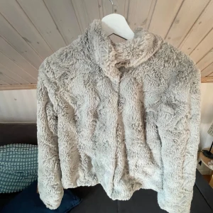 Beige teddyjacka från Vero Moda S - Supermjuk och fluffig teddyjacka från Vero Moda i beige färg. Jackan har långa ärmar och stängs med knappar framtill. Perfekt för dig som vill ha en cozy vibe under kyliga dagar.