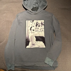 Limitato hoodie - Limitato hoodie med stor konstnärlig print framtill av en kvinna i kaninmask, designad av Ellen von Unwerth. Tröjan har huva och långa ärmar, perfekt för dig som gillar unika och kreativa plagg. Snygg och bekväm med en cool vibe. Passar S bra med