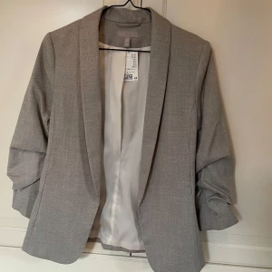 Kavaj - Gråbeige kavajjacka från HM. Aldrig använd, lapp kvar, nypris 399 kr