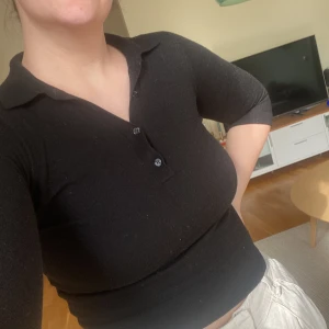 Svart polotröja i merinoull Massimo Dutti - Svart, tight polotröja från Massimo Dutti i 100% extrafin merinoull. Tröjan har trekvartsärm, krage och knappar framtill. Ett litet hål på armbågen som säkert går enkelt att fixa för den händige. 