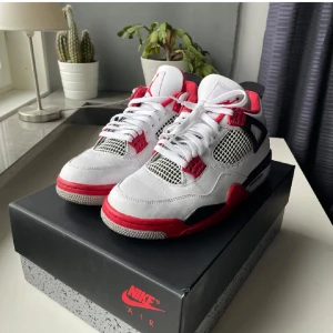 Nike Air Jordan 4 Fire Red sneakers - Nike Air Jordan 4 Fire Red med vit ovandel i skinn, röda och svarta detaljer samt meshpaneler. Klassisk siluett med snörning, synlig Air-sula och Jumpman-logga på plösen. Perfekta för dig som vill sticka ut med en ikonisk sneaker.