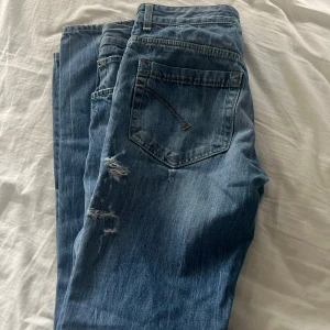 Dondup jeans - Säljer ett par blå jeans från Dondup med lite slitningar. Jeansen är storlek 33. Perfekta för dig som gillar en avslappnad och trendig look. Skriv privat för frågor!!!