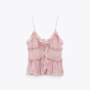 Rosa volangtop från Zara - Supersöt ljusrosa linnetopp från Zara med tunna axelband, volanger och knytning framtill. Toppen är luftig och har flera lager volanger. Ingår ej frakt 