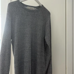 Grå stickad tröja från L.O.G.G. Strl S/M - En enkel och stilren grå stickad tröja från L.O.G.G. med rund halsringning och ribbade muddar. Perfekt för lager-på-lager och funkar året runt. Långärmad och i mjukt material som känns skönt mot huden. Skick 8/10 är storlek S men passar även M