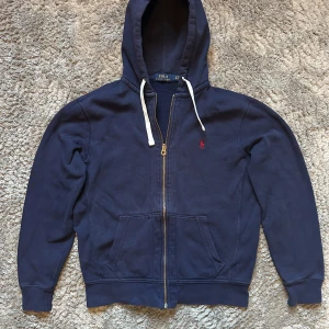 Ralph lauren tröja - Säljer denna hoodie med dragkedja från Ralph lauren✅säljs för att den börjar bli för liten. Tröjan har några lätta slitningar vid slutet av ärmen, men är i gott skick annars.Nypris: ca 1500. Hör av er vid minsta fundering😁