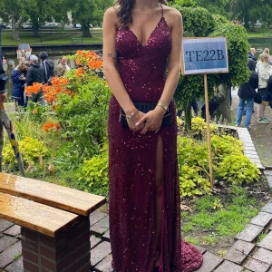 Vinröd glittrig balklänning med slits - Säljer en magisk vinröd långklänning med öppen rygg! Klänningen är täckt av glittriga paljetter och har en slits framtill✨Sitter figurnära och är perfekt för bal eller andra festligheter. Nypris 4200kr och storlek är mellan XS-S💖