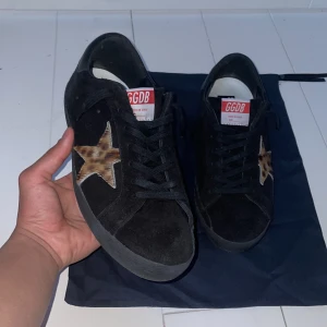 Golden goose skor  - Säljer dessa riktigt feta Golden goose skorna i svart mocka med leopardmönstererad stjärna! Skorna är i nyskick och är endast använda ett fåtal gånger, orginal storlek är 41 men passar upp möt 42! Nypris: 5000kr mitt pris endast: 2099kr Kontakta mig via funderingar!