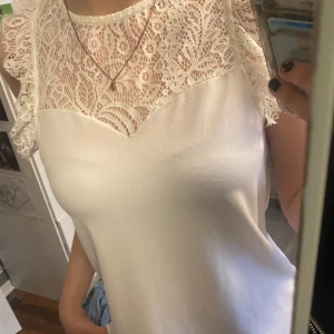 Vit top med spetsdetaljer - Säljer för den kommer aldrig till användning.