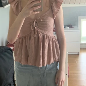 Rosa blus med volang från 157, XS - Supersöt ljusrosa blus från 157 i storlek XS. Aldrig använd. Pris kan diskuteras vid snabb affär.