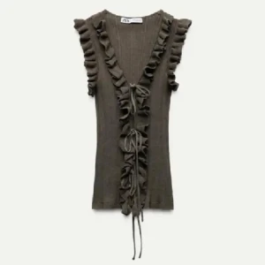 Grön volangtopp med snörning Zara - Supersnygg grön topp från Zara med volanger längs v-ringningen och axlarna. Toppen har snörning framtill och är ribbad för en extra cool look. Pris kan diskuteras💓