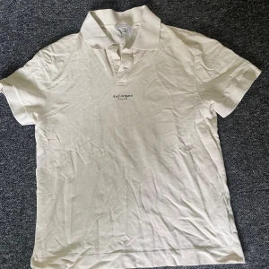 Beige pikétröja från Axel Arigato - Snygg beige pikétröja från Axel Arigato med klassisk krage och korta ärmar. Tröjan har diskret logga broderad på bröstet och är gjord i mjuk bomull. Passar på L men även bra på M 