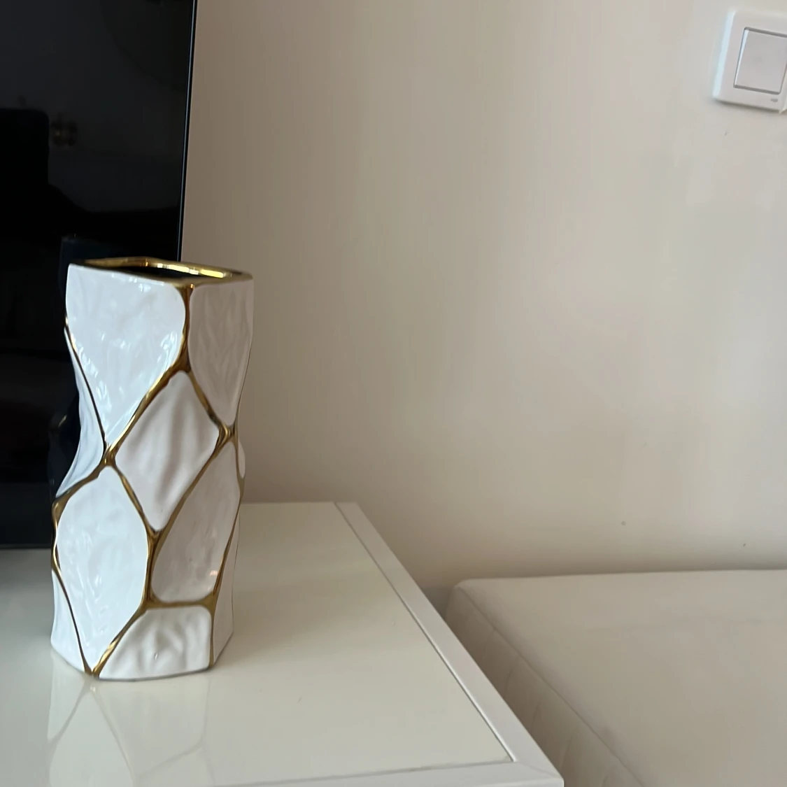 En vit vas med  geometriskt mönster i guld färg - 1