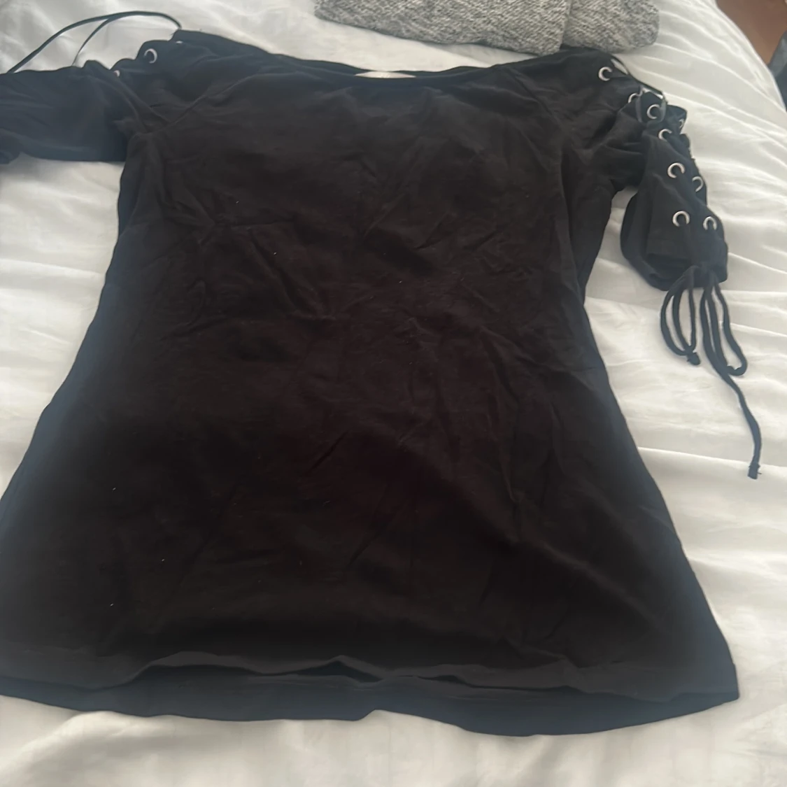 Svart topp med snörning på ärmarna