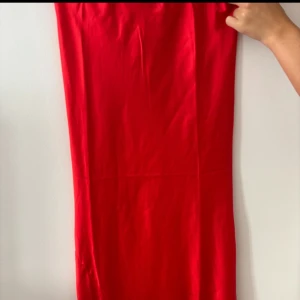 Röd satinkjol från Gina Tricot - Snygg röd långkjol från Gina Tricot i glansigt satintyg. Resårband i midjan! Den har lite volang ner till! Superfin till sommarens alla fester ❤️