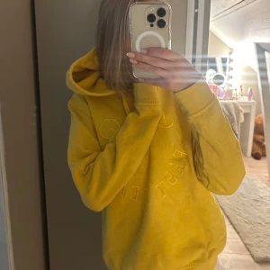 Gul hoodie från Ganni - Gul hoodie från Ganni med broderad text och peace-symboler framtill. Tröjan har huva med snörning och långa ärmar. Såå snygg!😍💞 #sthlmstil #ganni #gult #valentino