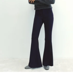 Mörkblå bootcut byxor - Snygga mörkblå bootcut byxor med hög midja och utsvängda ben. Byxorna har en stilren look och är perfekta för dig som gillar en trendig siluett. Tillverkade i ett mjukt material som sitter bekvämt hela dagen.