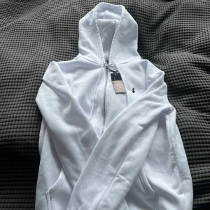 Ralph lauren zip - Säljer en helt ny vit zip-up från Polo Ralph Lauren, aldrig använd och fortfarande med originaltagg kvar. ✅ Äkta vara ✅ Storlek: S ✅ Material: 100 % polyester ✅ Nypris ca 1 600 kr  Passar perfekt för dig som vill ha en stilren, klassisk och sportig look med hög kvalitet.  💸 Mitt pris: 799