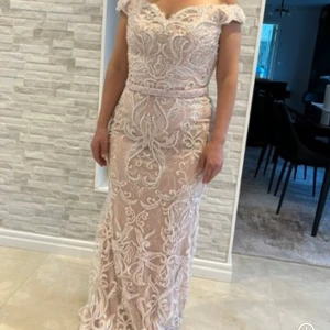 Champagnefärgad/rosa långklänning med pärlor! - Elegant och vacker utsmyckad festklänning i champagnefärg med vackra pärldetaljer .Offshoulder-modell med figurnära passform.Perfekt för bal eller fest. Storlek 36/38.