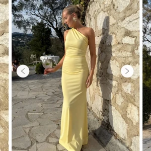 Ljusgul långklänning med oneshoulder - Supersnygg ljusgul långklänning med oneshoulder och figurnära passform. Klänningen har lätt rynkade detaljer vid midjan och axeln, vilket ger en elegant siluett. Perfekt för bal eller sommarens fester! strl 34 men passar mig som vanligtvis har 36, slutsåld på hemsidan!