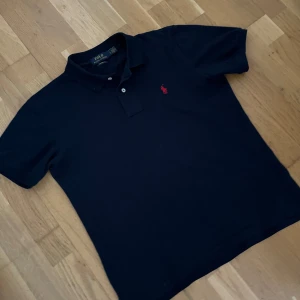 Ralph lauren pike  - Skick 9/10, använt kanske 3-4 gånger och inga skador eller hål, inga missfärgningar heller. Färg navy blue. Storlek L men sitter som S för har tvättats fel och har förminskats därför säljer jag. (Passar inte mer). Skriver storlek S i beskrivningen. Skriv om funderingar och priset är ej hugget i sten   Längd = 68 cm