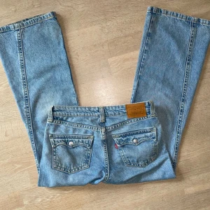 Levis 501 ljusblå lågmidjade bootcut jeans - Dessa har bara används typ tre ggr, köpte de för ett år sedan för 1500kr. Normal i storleken men eftersom de är jeans kan de töjas ut vid användning, men om man tvättar de kommer de krympa till sin ursprungliga form. Storleken är W27.