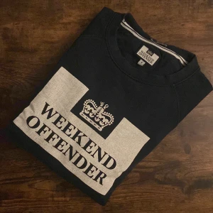 Weekend Offender Sweatshirt - Weekend Offender sweatshirt i mörkblått, storlek Small. Mjuk och skön bomullsblandning. Kondition 7/10 med lättare tecken på användning men utan fläckar eller skador. Perfekt för casual och streetwear. Stilren och tidlös design som passar till det mesta i garderoben. 