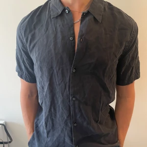 Svart kortärmad skjorta  - Snygg svart skjorta med korta ärmar och klassisk krage. Perfekt till sommaren. Köpt från HM