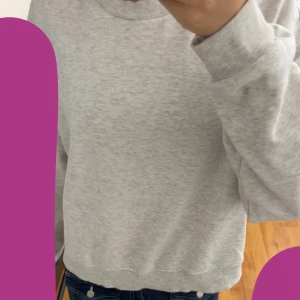 Ljusgrå sweatshirt i bomull - En enkel och stilren ljusgrå sweatshirt med rund hals och långa ärmar. Tröjan har en loose passform och är tillverkad i mjuk bomull, perfekt för en avslappnad look. Passar bra till jeans eller leggings.