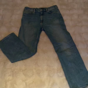 Blå raka jeans från GANT - Snygga blå jeans från GANT med klassisk femficksmodell och broderad logga på fickan. Jeansen har rak passform och normal midja, tillverkade i slitstarkt denimtyg. Perfekta till sneakers eller boots för en chill look. Köptes för 800kr. Vill du har mer bilder säg bara till