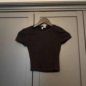 Svart croppad topp från H&M Divided - Enkel svart croppad topp från H&M Divided i storlek XXS.