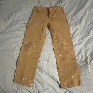 Dickies Carpenter pants - Säljer ett par bruna cargopants från Dickies med raka ben och flera praktiska fickor. Byxorna är i bomull och har klassisk Dickies-logga bak. Perfekta för dig som gillar workwear-stil eller skate och vill ha slitstarka byxor. 