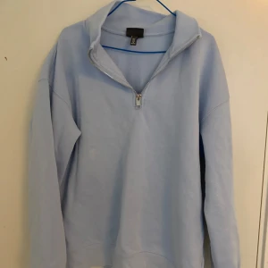 Ljusblå half zip tröja från H&M - Supermysig ljusblå tröja från H&M med relaxed fit och half zip-dragkedja. Tröjan har lång ärm och hög krage, perfekt för lager på lager. Tillverkad i mjuk bomullsmix som känns skön mot huden. Enkel och stilren design som funkar till allt.