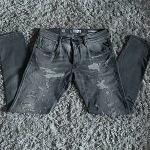Replay Anbass jeans med slitningar - Säljer dessa riktigt snygga Replay Anbass jeansen med slitningar ner till knäna. De är i riktigt fint skick utan defekter. Jeansen är i storlek 32/32 och är slim fit. Bara att skriva över frågor och funderingar.