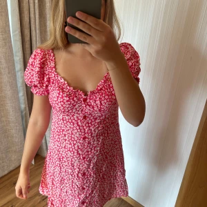 Röd blommig kortklänning med puffärm - Aldrig använd, normal i storleken