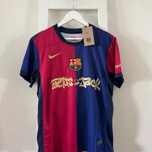 FC Barcelona Lamine Yamal tröja Nike S - FC Barcelona matchtröja i blått och rött med guldiga detaljer, Nike-logga och klubbmärke på bröstet. Lamine Yamal och nummer 19 på ryggen. Kortärmad modell i lätt och ventilerande material, perfekt för fotboll eller att bära som supporter.