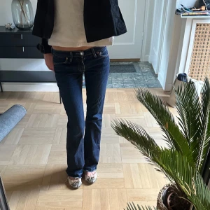 Levis mörkblå bootcut jeans - Säljer ett par vintage mörkblå Levis  jeans med bootcut passform och låg midja. Klassiska femficksjeans med snygga kontrastsömmar och Levis-logga på bakfickan. Perfekta för dig som gillar en tidlös och avslappnad stil.