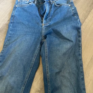 Blå bootcut jeans Curve XS - Snygga blå jeans i bootcut-modell från Curve. Klassisk femficksdesign med dragkedja och knapp framtill. Jeansen har en lätt utsvängd passform nertill och är samt högmidjade. De är tillverkade i mjukt denimtyg som sitter skönt hela dagen.