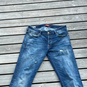 Blå jeans Jack & Jones 33/34 - Säker dessa stilrena jeans ifrån Jack and Jones. Jeansen har fina slitningar på sig. Pris kan diskuteras vid snabb affär!!