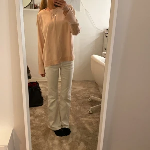 Ljusbeige stickad tröja med vida ärmar - Superfin ljusbeige stickad tröja med avslappnad passform och vida, långa ärmar. Tröjan har ribbade muddar vid ärmslut och nederkant, perfekt för en chill och stilren look. Passar perfekt till jeans eller kjol för en enkel men snygg outfit.