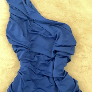 Blå topp från bikbok - Säljer en blå one shoulder topp från BikBok i storlek S som även passar Xs. Har nästan aldrig använt den, fint skick🥰