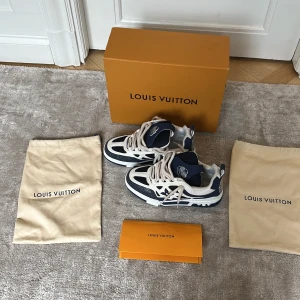 Louis Vuitton blå/vita sneakers - Snygga Louis Vuitton sneakers i blått💙 och vitt🤍 med coola LV-detaljer. Skorna har meshpaneler, skinn och syntet, samt tjocka vita snören. Sulan är blå/vit med tydlig Vuitton-logga undertill. Perfekta för dig som vill sticka ut med lyxig streetstyle. Box och två dustbags medföljer. Kvitto kan visas vid förfrågan✅