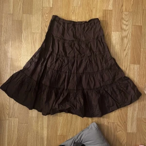 Brun volangkjol i bomull - Säljer en brun långkjol med flera volanger. Använd fåtal gånger. Barnstorlek 160 men passar xs, eventuellt s. 🩷