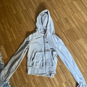 Beige hoodie med dragkedja Gina Tricot - Snygg beige hoodie från Gina Tricot i mjukt material. Tröjan har huva, långa ärmar, fickor framtill och hel dragkedja. Perfekt för en chill och avslappnad stil. Passar dig som gillar basic men ändå vill ha något fräscht.