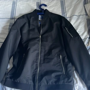 Svart bomberjacka Jack & Jones OBS köparen står för frakt  - Svart Jack and Jones jacka lite mer vår/höst aktig kostade 350 säljs för 99 aldrig använd med prislapp på. Köparen står för frakt eller mötas i centrala Göteborg 
