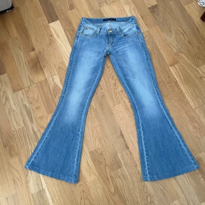 Blå jeans  - Supersnygga lågmidjade bootcut jeans i färgen blå! Vintage och går inte att få tag på längre! Storlek 9, midja: 34 cm, midjehöjd: 17 cm, innerben: 74 cm